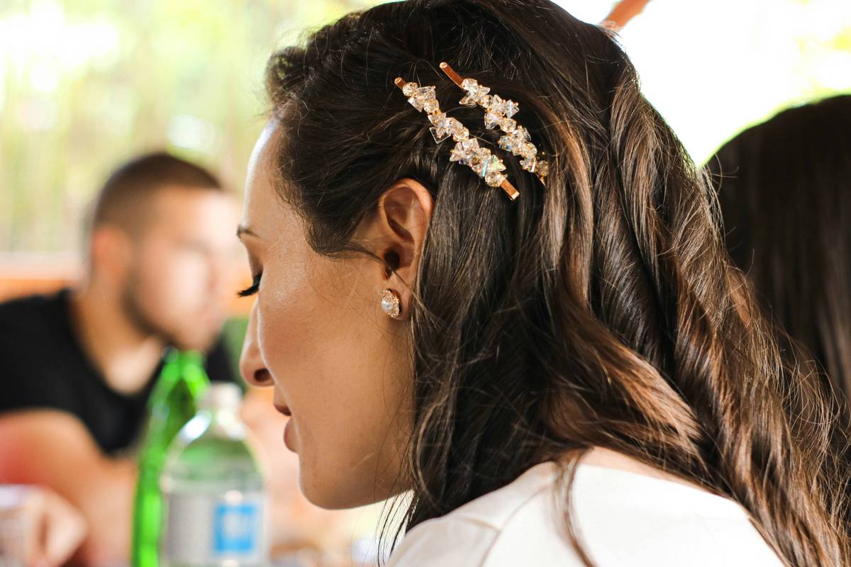 A woman wearing a delicate gold minimalist hair crown at a garden party.