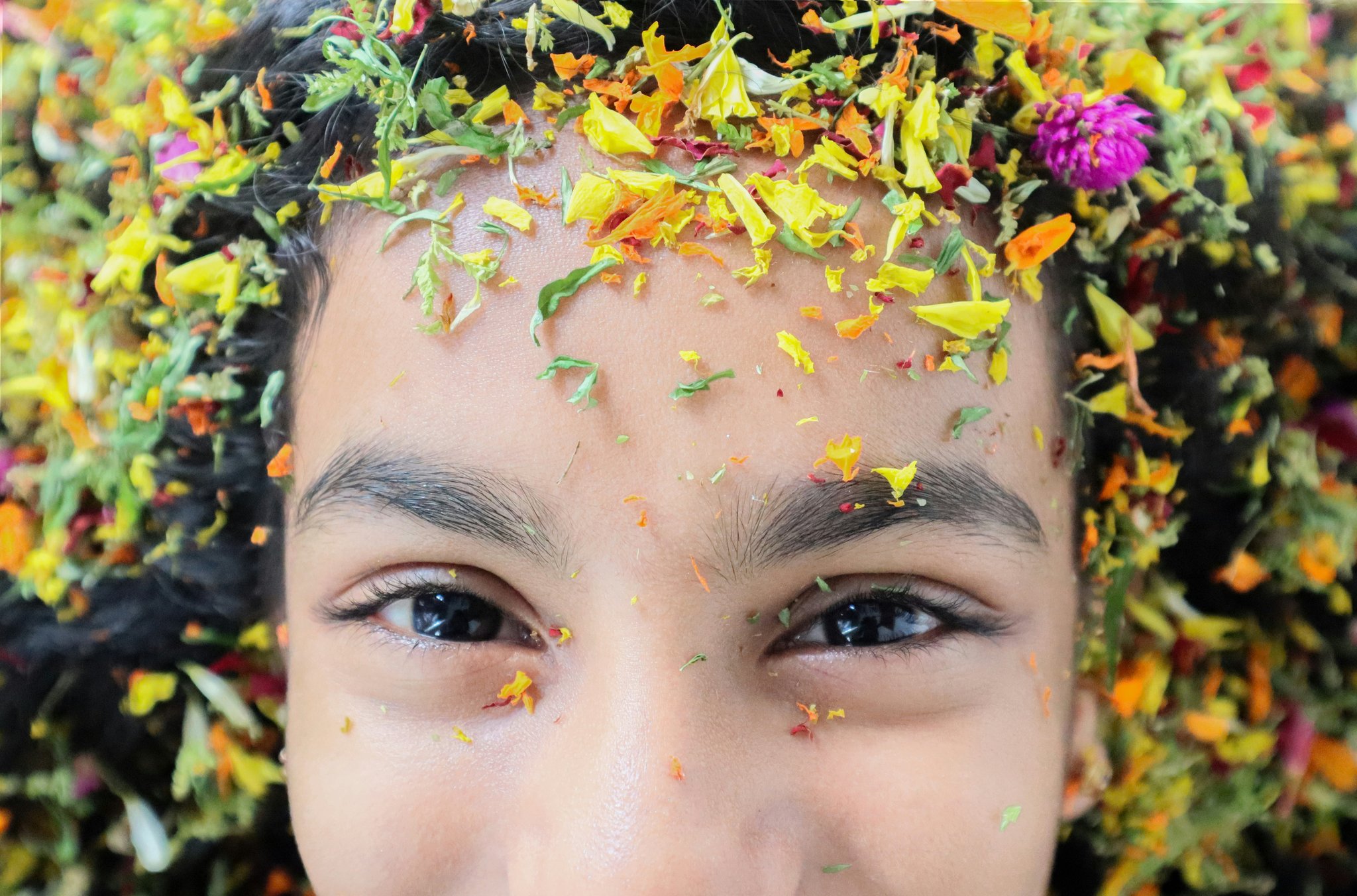 Close-up image of a delicate floral hair accessory with silk petals and gold leaves