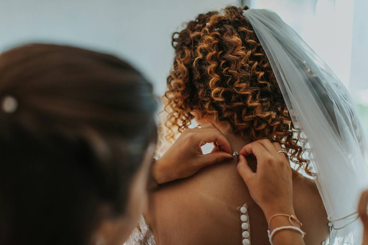 Close-up of a floral crown being pinned into braided hair.